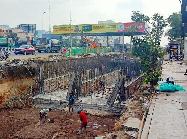 An unfinished stretch of the Pallavaram Thoraipakkam Radial Road with exposed drain pits and visible rods, depicting delays in construction and potential hazards for the upcoming monsoon season.