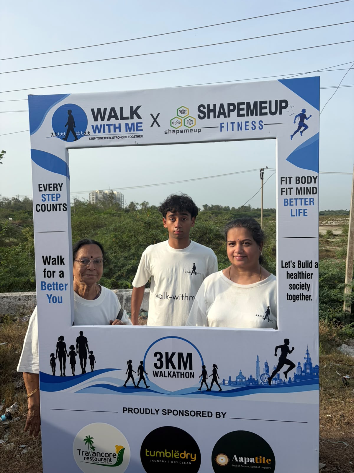 Participants pose outdoors at the Walk With Me 3KM walkathon selfie frame in Padur
